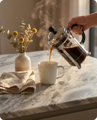 Coffee being poured on a natural stone benchtop